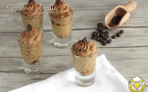 Delizioso spumone al caffè in bicchierini, guarnito con chicchi di caffè e cacao.