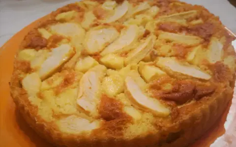 Una torta di mele dorata e soffice, con fette di mela caramellate in superficie. Probabilmente la torta di mele più buona che abbia mai mangiato.