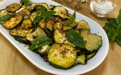 Zucchine alla scapece dorate e condite con menta fresca, aglio e peperoncino. Un contorno saporito e colorato.