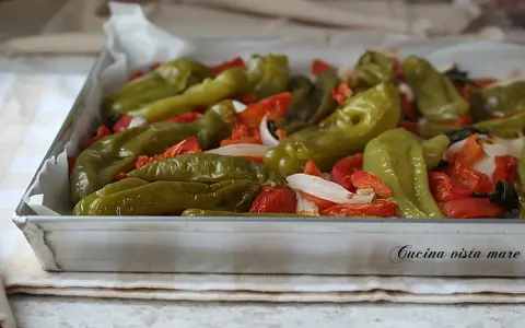Friggitelli al forno con pomodori e cipolla, un contorno saporito e colorato, pronto per essere gustato.