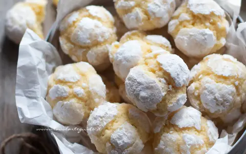 Biscotti al limone spolverati di zucchero a velo, morbidi e profumati, pronti per essere gustati.