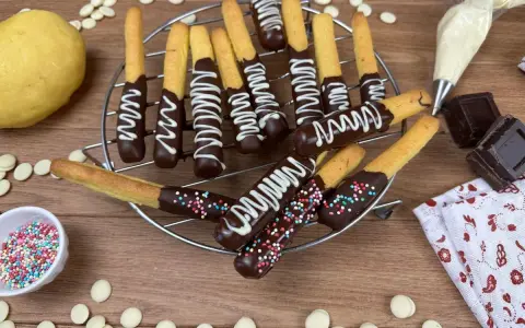 Biscotti al cioccolato decorati con glassa bianca e zuccherini colorati, pronti per essere gustati.