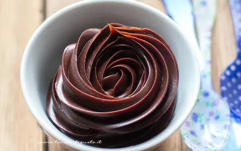 Una spirale perfetta di crema al cioccolato in una ciotola bianca, pronta per essere gustata.