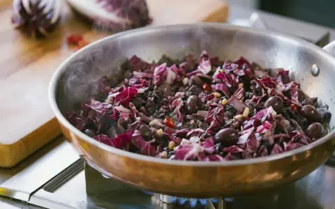 Radicchio in padella con olive e pinoli, un contorno saporito che profuma di casa.