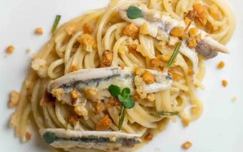 Spaghetti con burro e alici, croccanti pangrattato e erbe aromatiche. Un piatto semplice ma gustoso.
