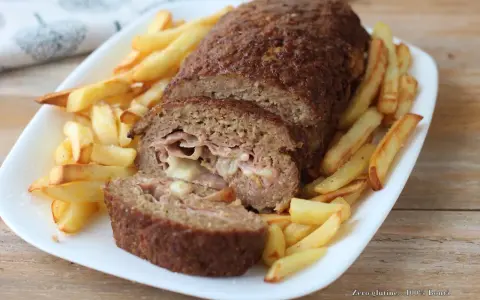 Polpettone ripieno di prosciutto e formaggio, cotto in friggitrice ad aria, servito con patatine fritte croccanti.