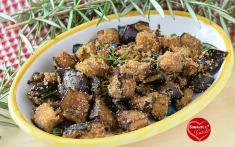 Melanzane in padella con pangrattato, croccanti e dorate, guarnite con rosmarino fresco. Un contorno saporito e invitante.