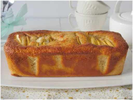 Plumcake alle mele dorato e soffice, con mele a vista in superficie, pronto per essere gustato.