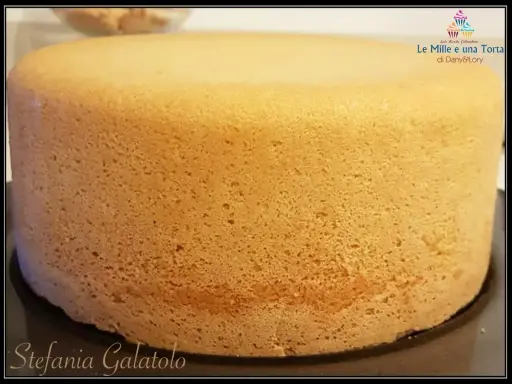 Un pan di spagna sofficissimo, dorato e invitante, pronto per essere farcito. La sua consistenza perfetta promette una torta deliziosa.