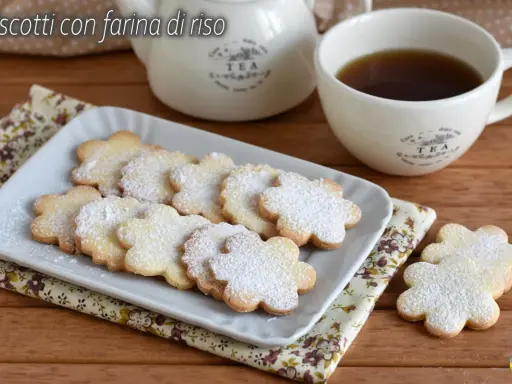 Biscotti con farina di riso a forma di fiore, spolverati di zucchero a velo, serviti con una tazza di tè.