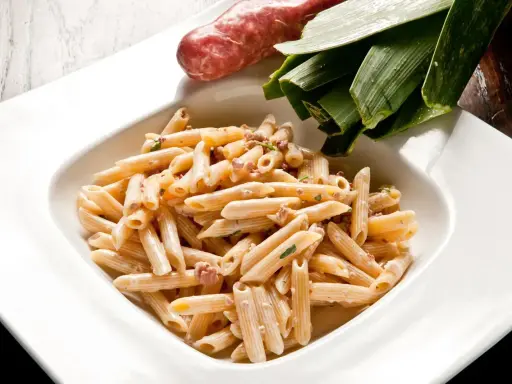 Penne cremose con salsiccia e verdure, un piatto di pasta alla norcina che invita alla tavola.