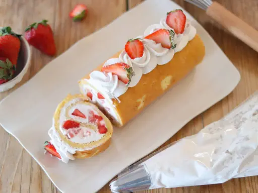 Rotolo panna e fragole decorato con panna montata e fragole fresche, pronto per essere gustato.