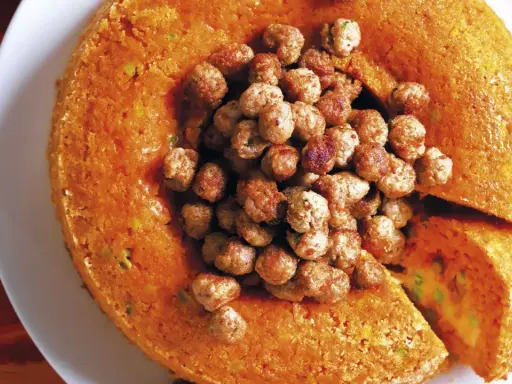 Tortino arancione ripieno, con polpettine al centro. Un classico dei primi piatti della domenica, invitante e saporito.