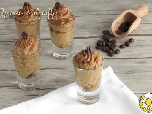 Delizioso spumone al caffè in bicchierini, guarnito con chicchi di caffè e cacao.