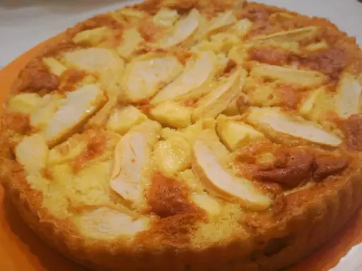 Una torta di mele dorata e soffice, con fette di mela caramellate in superficie. Probabilmente la torta di mele più buona che abbia mai mangiato.