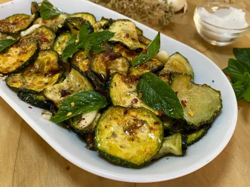 Zucchine alla scapece dorate e condite con menta fresca, aglio e peperoncino. Un contorno saporito e colorato.