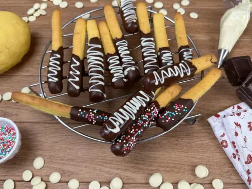 Biscotti al cioccolato decorati con glassa bianca e zuccherini colorati, pronti per essere gustati.