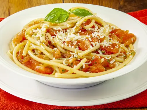 Un piatto invitante di pasta alla carrettiera, con pomodoro fresco, basilico e abbondante formaggio grattugiato.