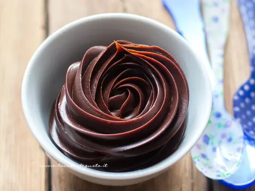 Una spirale perfetta di crema al cioccolato in una ciotola bianca, pronta per essere gustata.