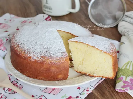 Torta yogurt greco soffice e profumata, cosparsa di zucchero a velo. Perfetta per la colazione o la merenda.