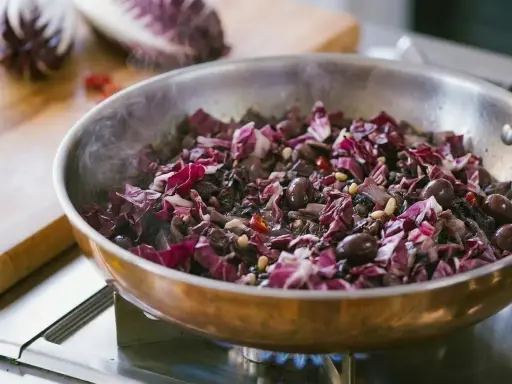 Radicchio in padella con olive e pinoli, un contorno saporito che profuma di casa.