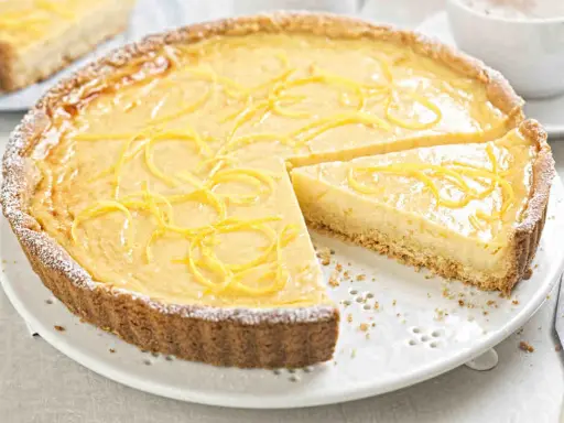 Una deliziosa crostata con crema pasticcera, guarnita con scorza di limone e spolverata di zucchero a velo.