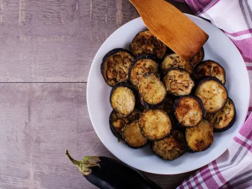 Fette di melanzane grigliate in friggitrice ad aria, dorate e pronte per essere gustate.