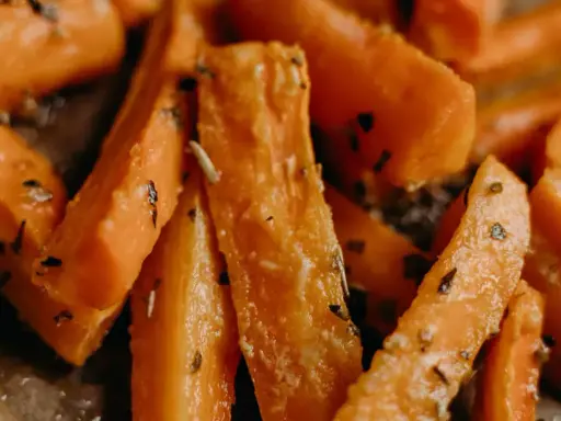 Carote in padella, tagliate a bastoncino e condite con erbe aromatiche, pronte per essere gustate.