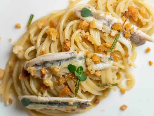 Spaghetti con burro e alici, croccanti pangrattato e erbe aromatiche. Un piatto semplice ma gustoso.