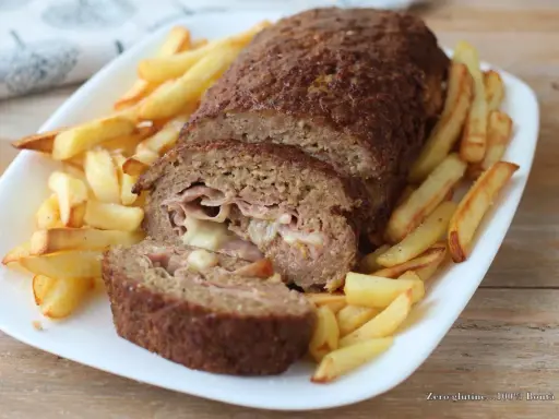 Polpettone ripieno di prosciutto e formaggio, cotto in friggitrice ad aria, servito con patatine fritte croccanti.