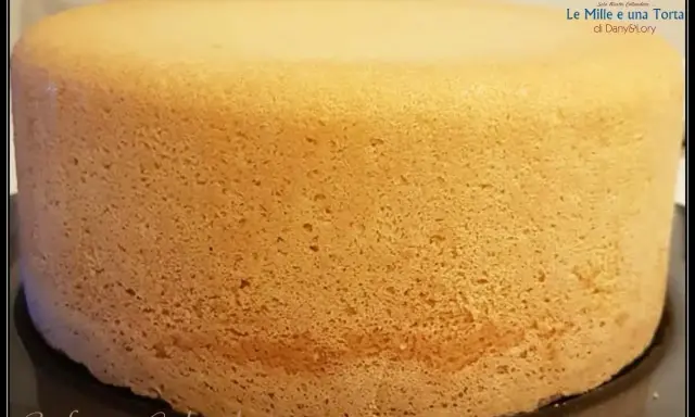 Un pan di spagna sofficissimo, dorato e invitante, pronto per essere farcito. La sua consistenza perfetta promette una torta deliziosa.