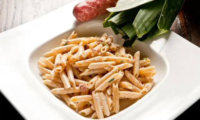 Penne cremose con salsiccia e verdure, un piatto di pasta alla norcina che invita alla tavola.