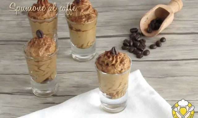 Delizioso spumone al caffè in bicchierini, guarnito con chicchi di caffè e cacao.
