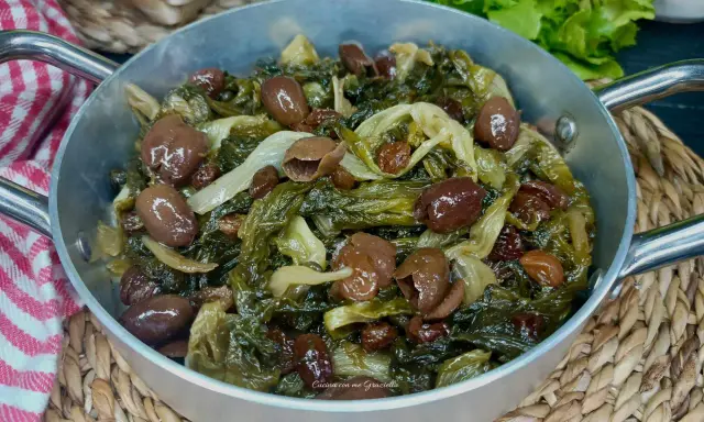 Scarola in padella con olive e uvetta, un contorno saporito e colorato, pronto per essere gustato.