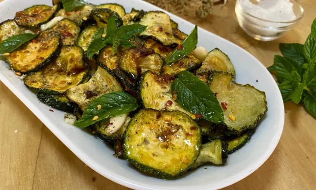 Zucchine alla scapece dorate e condite con menta fresca, aglio e peperoncino. Un contorno saporito e colorato.