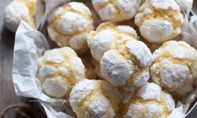 Biscotti al limone spolverati di zucchero a velo, morbidi e profumati, pronti per essere gustati.
