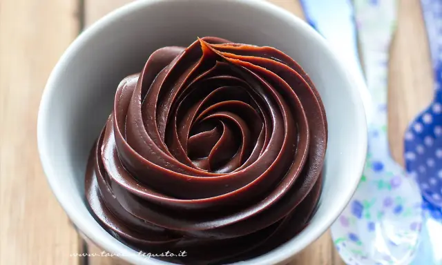 Una spirale perfetta di crema al cioccolato in una ciotola bianca, pronta per essere gustata.