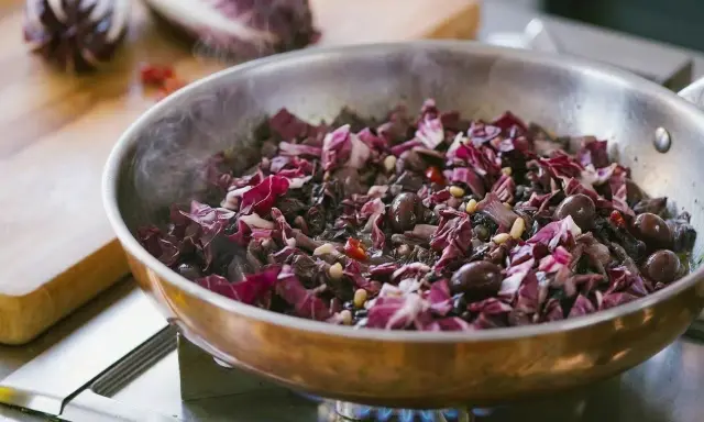 Radicchio in padella con olive e pinoli, un contorno saporito che profuma di casa.