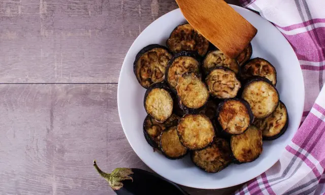 Fette di melanzane grigliate in friggitrice ad aria, dorate e pronte per essere gustate.