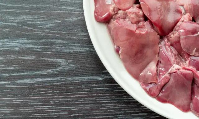 Piatto bianco con durelli di pollo crudi, pronti per essere cucinati.