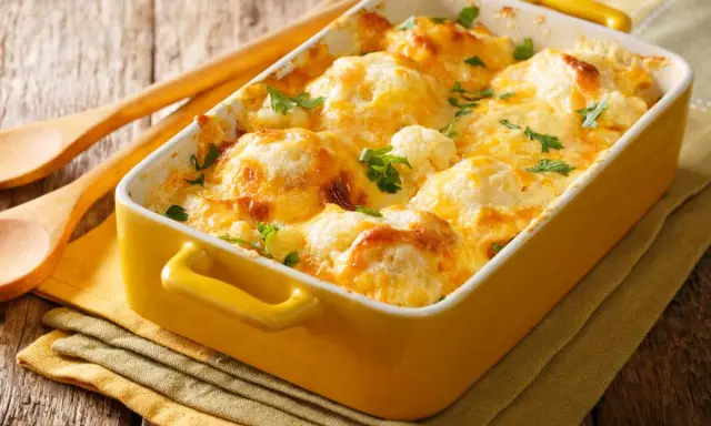 Cavolfiore al forno con pangrattato e formaggio filante, guarnito con prezzemolo fresco. Un piatto invitante e saporito.