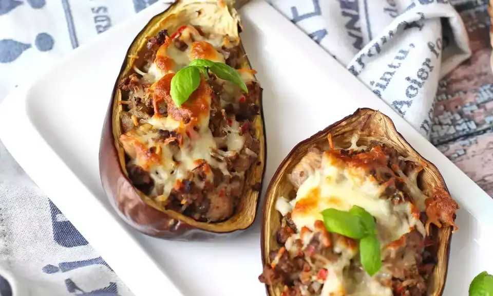 Melanzane ripiene al forno velocissime, con un saporito ripieno e formaggio filante, guarnite con basilico fresco.
