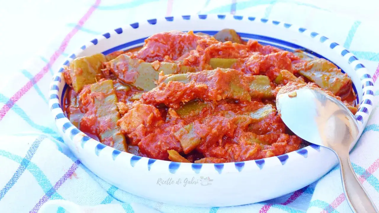 Un piatto invitante di taccole al pomodoro, cotte lentamente e servite in una ciotola decorata.