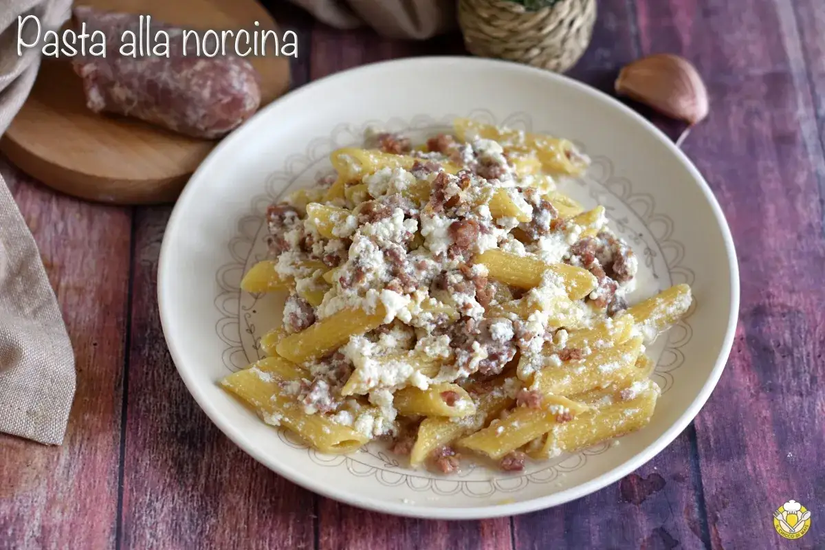 Piatto di pasta alla norcina con salsiccia sbriciolata e ricotta cremosa, pronto per essere gustato.