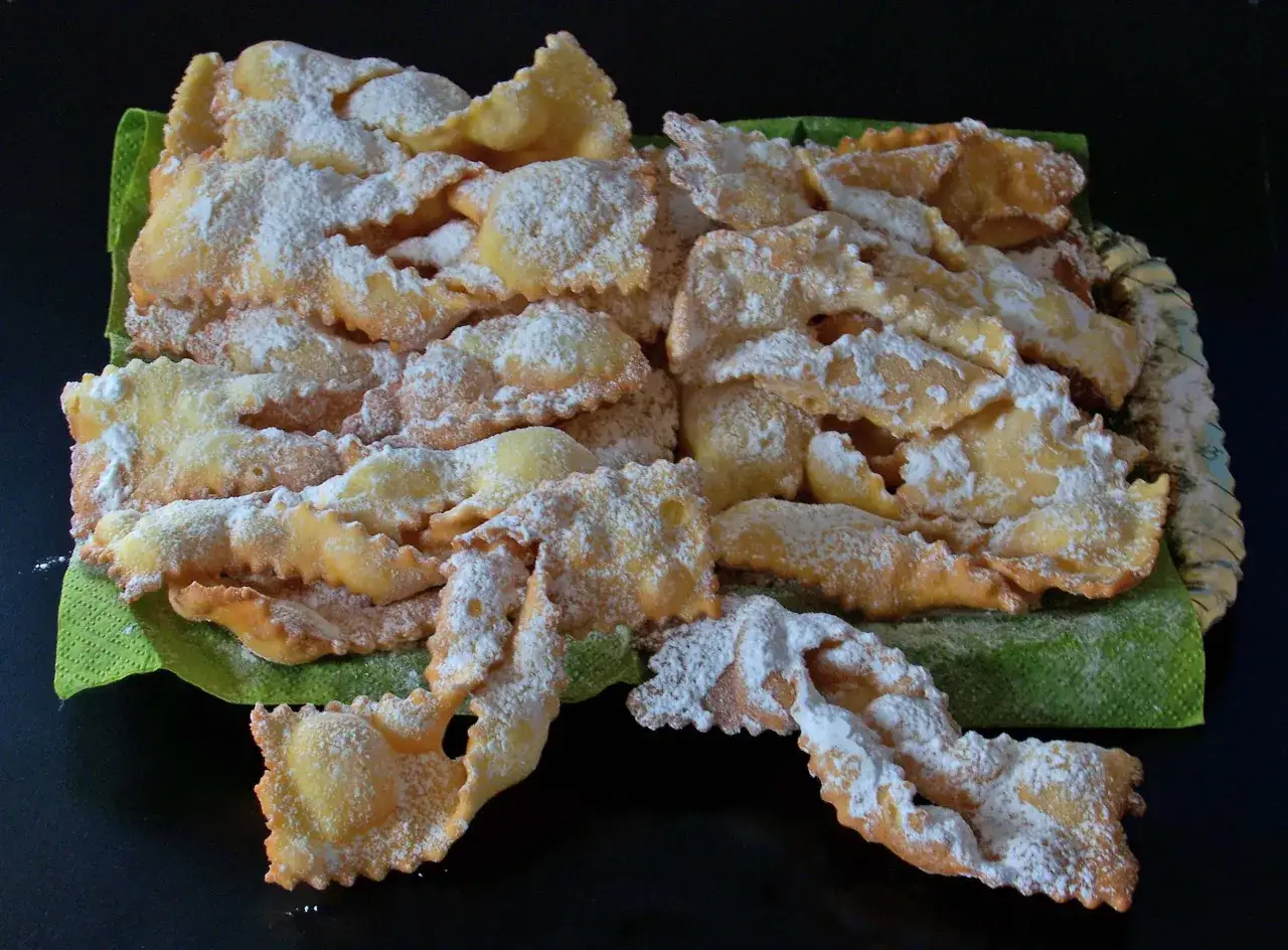 Chiacchiere croccanti, la ricetta della nonna, cosparse di zucchero a velo, un dolce tradizionale che sa di casa.
