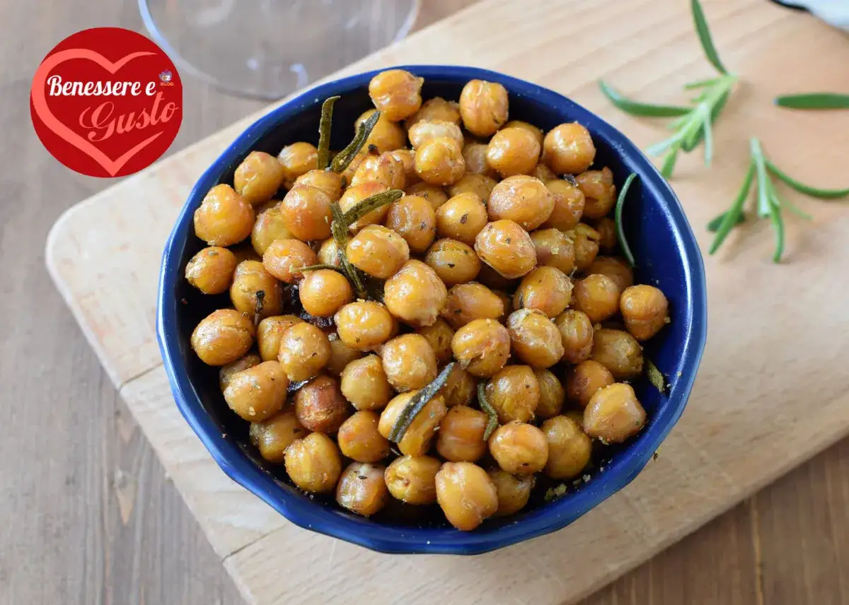 Ceci croccanti al forno, dorati e profumati al rosmarino, serviti in una ciotola blu. Uno snack sano e gustoso.