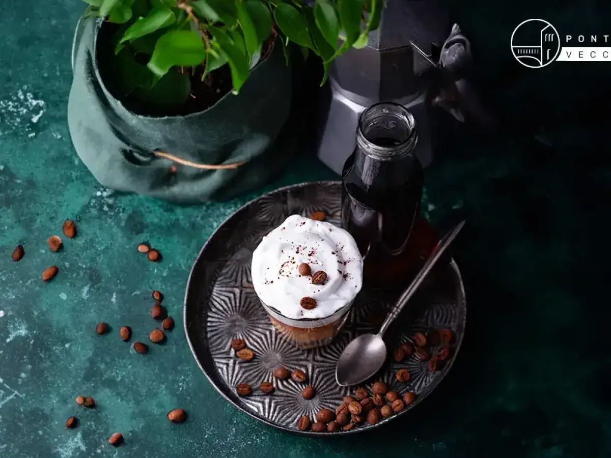 Un delizioso spumone al caff&egrave;, guarnito con panna montata e chicchi di caff&egrave;, pronto per essere gustato.