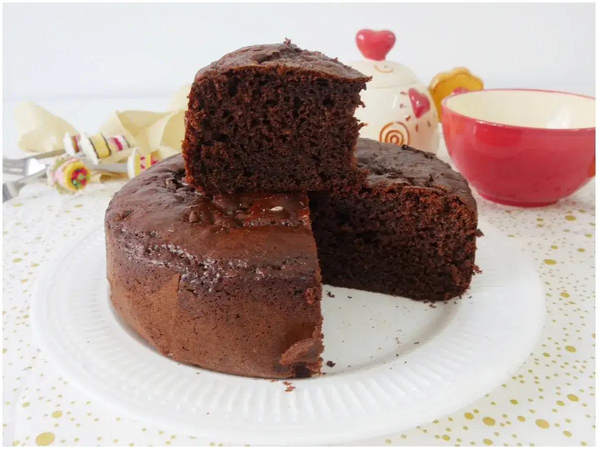 Torta yogurt e cioccolato soffice e golosa, con una fetta sollevata. Perfetta per la colazione o la merenda.