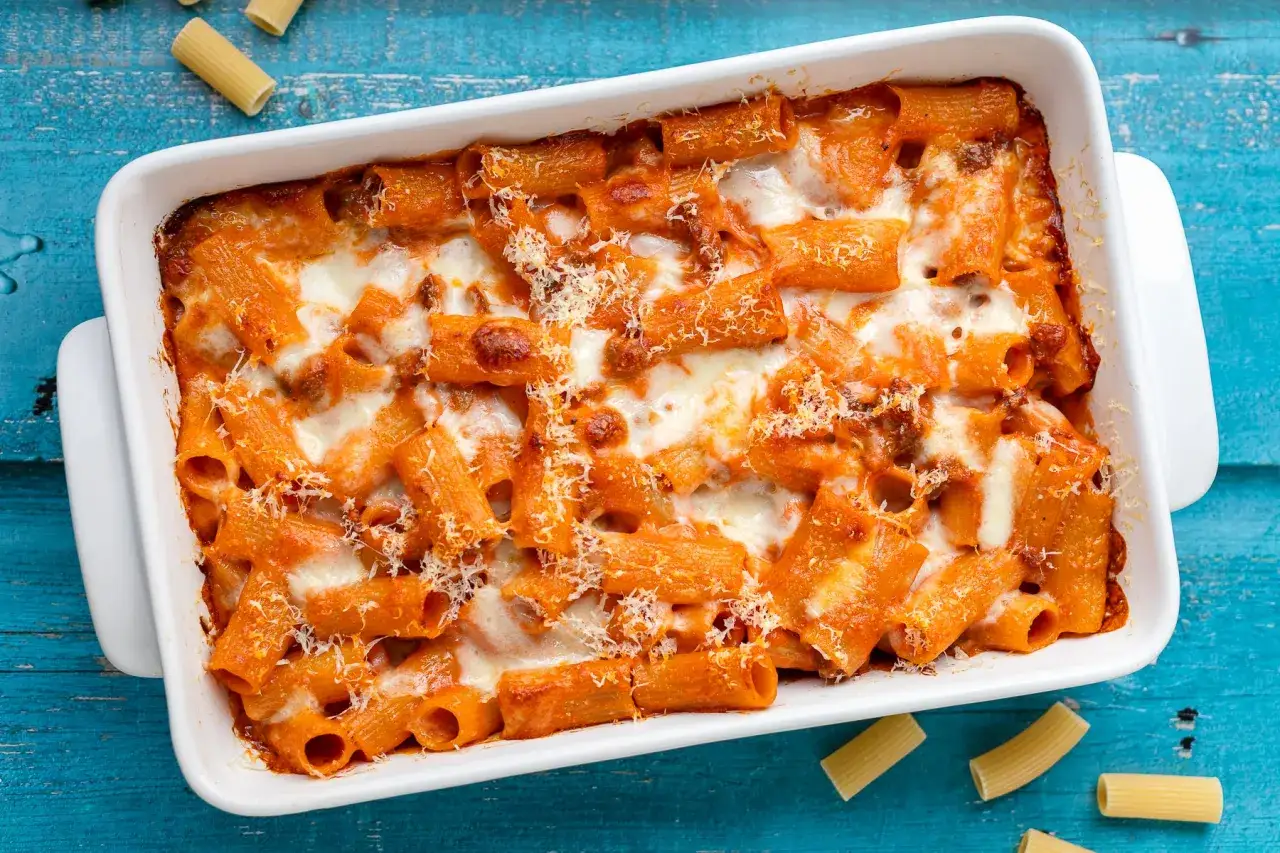Un invitante pasta al forno, con rigatoni conditi con sugo rosso e abbondante formaggio filante, pronto per essere gustato.