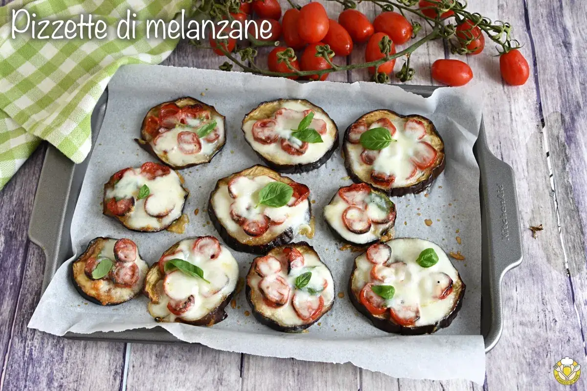 Pizzette di melanzane alla pizzaiola, gustose e colorate, pronte per essere infornate.